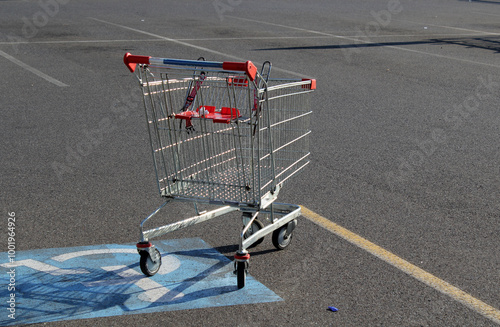 Metal shopping cart trolley abandoned in a handicap parking space