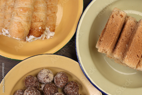 Bangladesh Indian cone shaped hard flaky puff pastry stuffed cream roll Indian Milk Cake Alwar Ka Mawa dry flaky biscuit like sweet treat traditional  Narkel Naru Coconut ladoo laddu with Jaggery photo