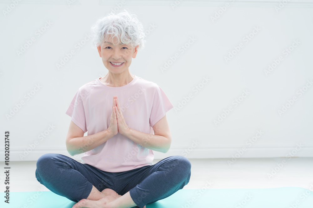 ヨガの瞑想をするシニア女性 ヨガの瞑想をするシニア女性