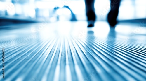 A blurred perspective of a floor with footsteps, suggesting movement in a spacious environment.