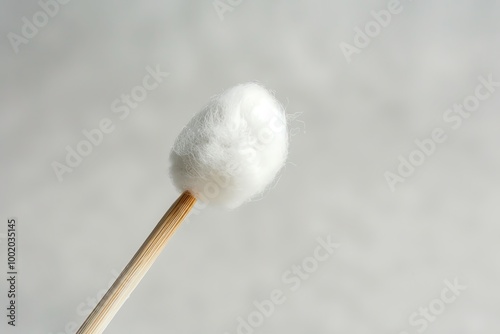 Close-up of a single cotton swab against a soft, neutral background. Perfect for hygiene, healthcare, and cleaning themes.