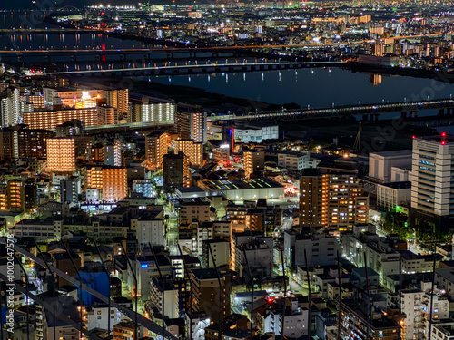 A mesmerizing aerial view of the city at night ; A breathtaking panorama of Osaka's illuminated cityscape