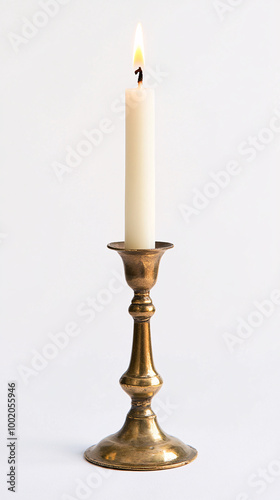 single white candle burning in brass candlestick on white background