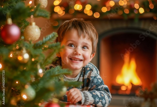 A little boy sitting in front of a Christmas tree.