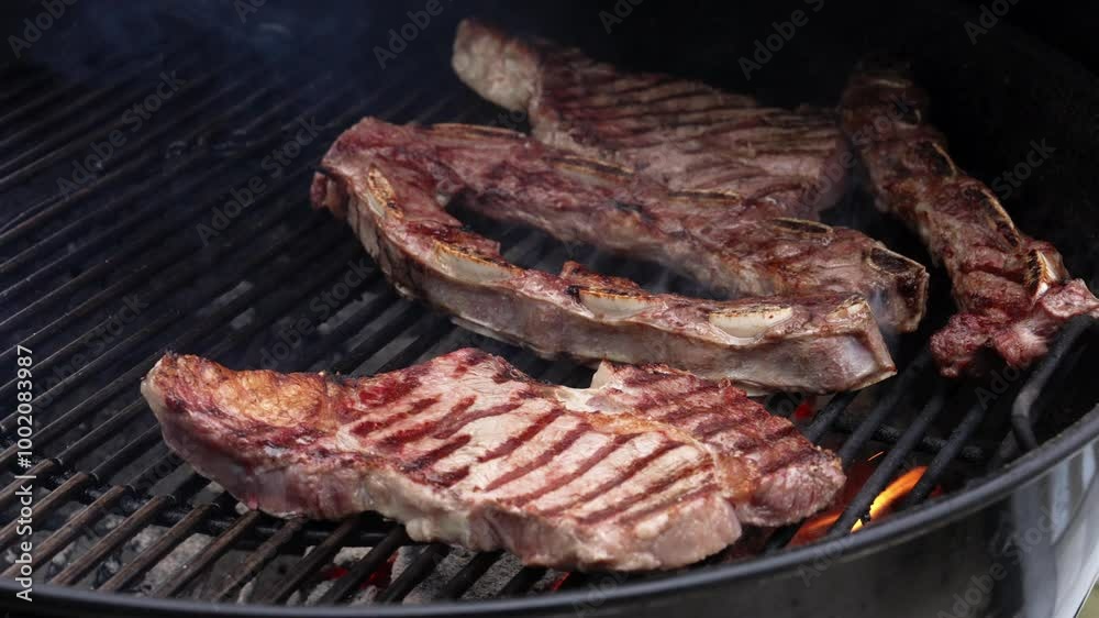 Costillas a la parrilla con flamas intensas y humo