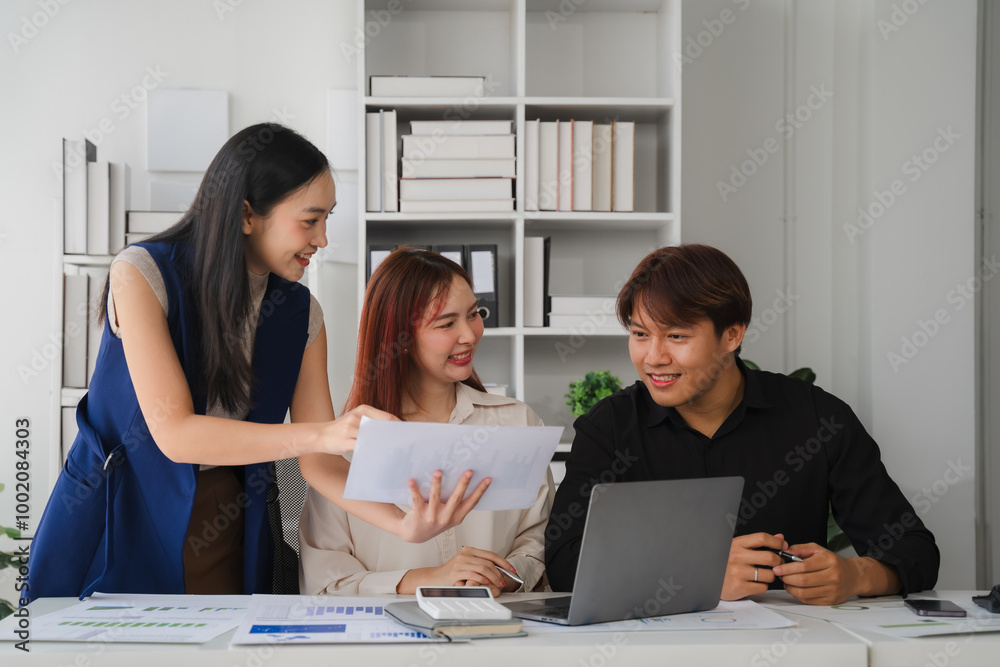 Collaborative Analysis: A team of Asian professionals collaborates on a project, engaged in a discussion and reviewing documents. The image evokes a sense of teamwork, communication, and focus. 