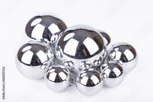 Minimalist arrangement of silver Christmas balls of different sizes on a clean white background, highlighting their glossy appearance photo