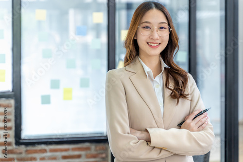 Happy young business woman smiling at camera from her office desk