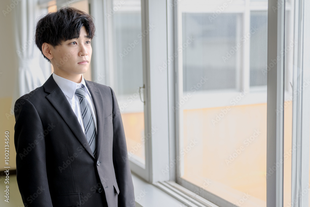 窓の外を見つめるビジネスマン