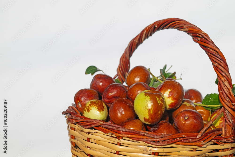 Ripe brown jujube fruits in a basket, isolated on a white background. Delicious, ripe berries in a basket. Close-up. Ripe brown jujube fruits in a basket, isolated on a white background. Delicious, ripe berries in a basket. Close-up.