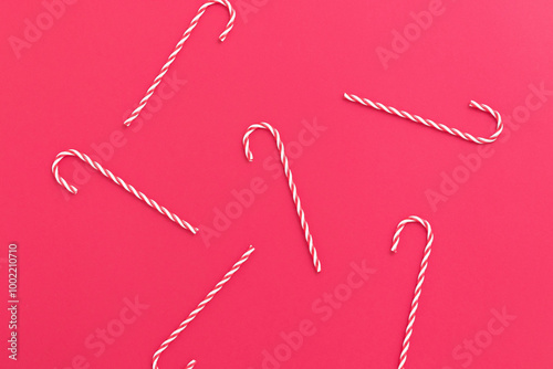 Red and white Christmas candy canes, Christmas ornaments on a red background