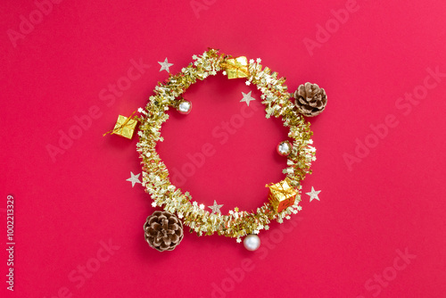 Shiny gold and gold Christmas wreath on red textured background