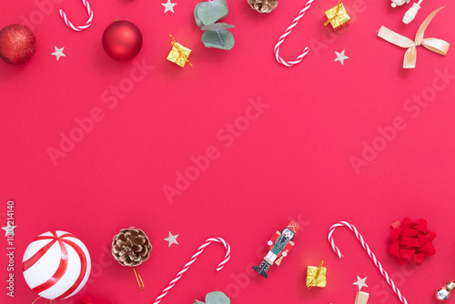 Red background with Christmas ornaments, candy cane, presents, golden balls, nutcrackers, golden stars