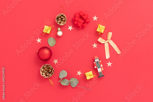Christmas ornament wreath with Christmas ornaments, candy cane, presents, golden balls on red background