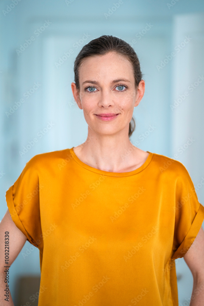 Smiling mature woman wearing yellow t-shirt at home