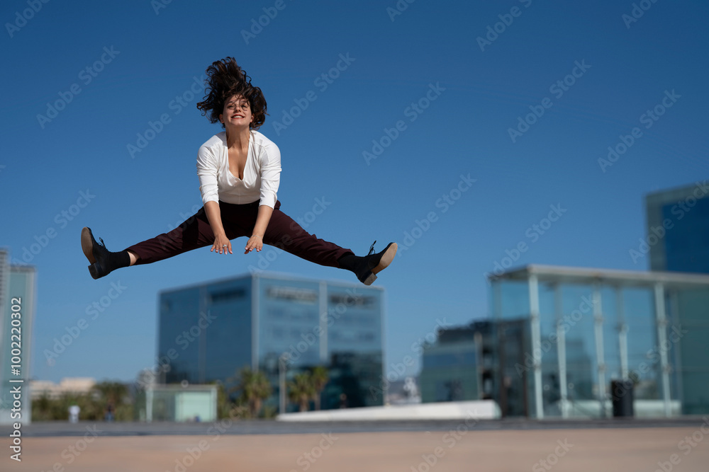 Businesswoman jumping in air at city centre Businesswoman jumping in air at city centre
