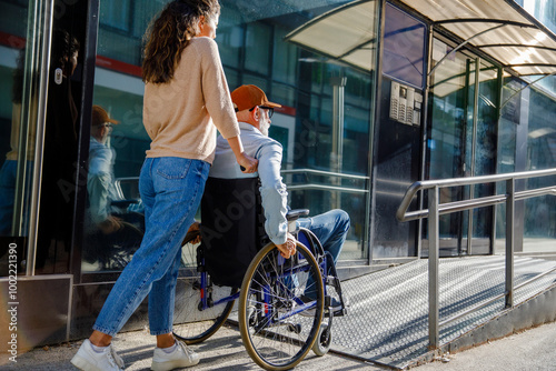 Caregiver pushing senior man in wheelchair on ramp