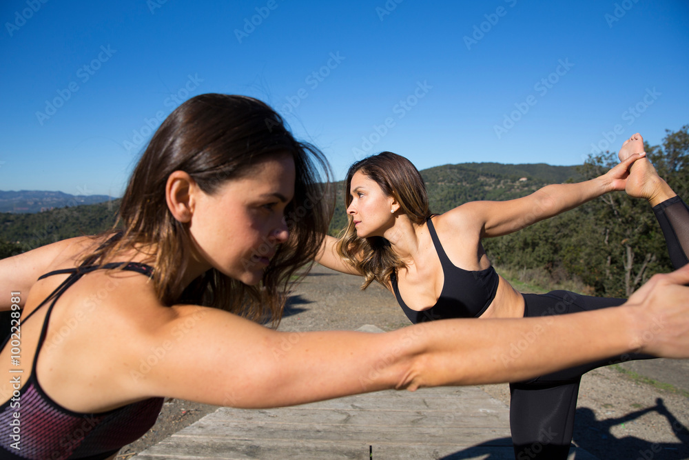 Friends doing bow pose under blue sky Friends doing bow pose under blue sky