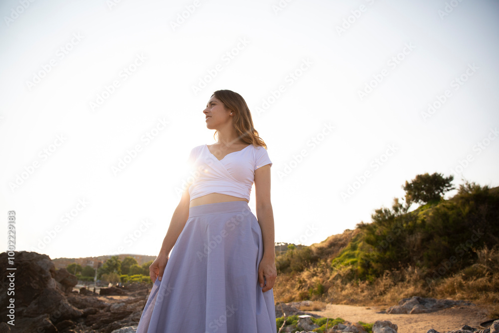 Thoughtful woman wearing skirt standing under clear sky Thoughtful woman wearing skirt standing under clear sky