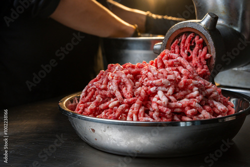 Fotografía Process of fresh meat grinding in the kitchen with modern electric grinder, top