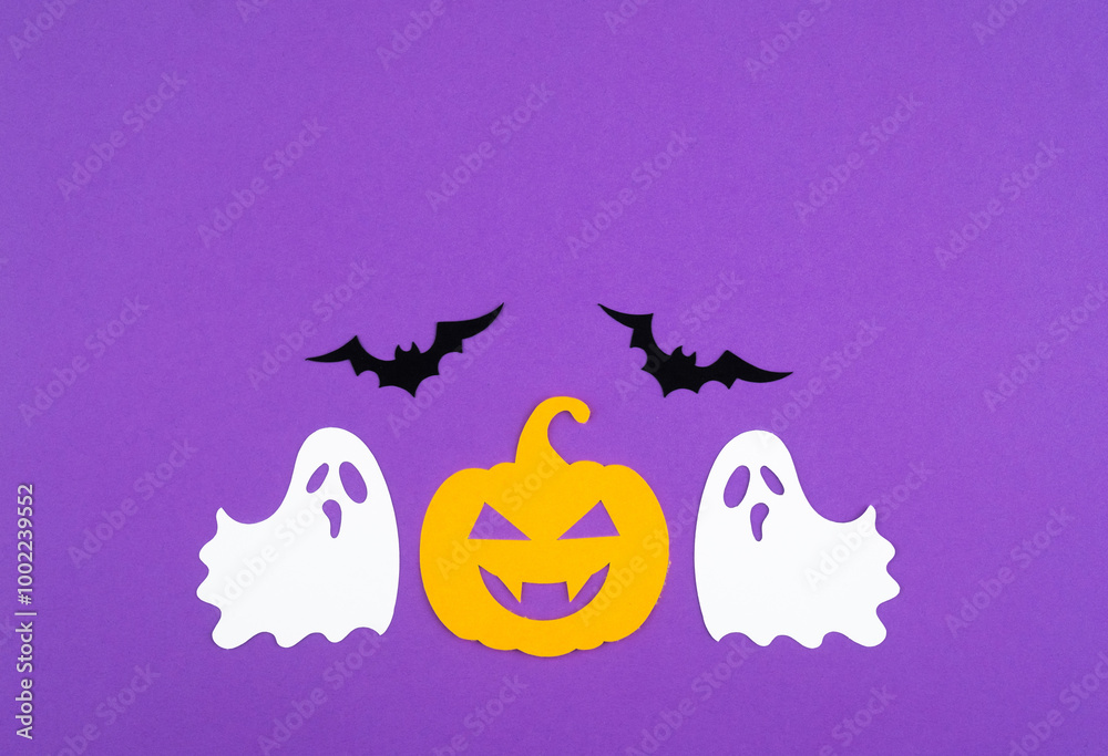 Fototapeta premium Colorful Halloween decorations featuring ghosts and a pumpkin against a vibrant purple background