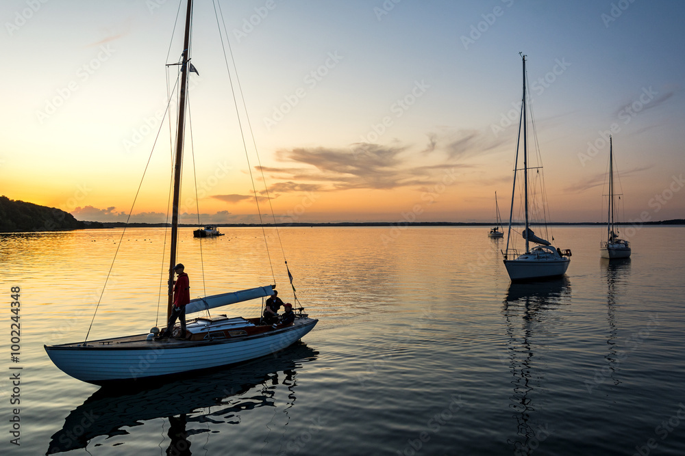 Sailing boats coming back into the harbour during scenic sunset at the Baltic Sea in Northern Germany Sailing boats coming back into the harbour during scenic sunset at the Baltic Sea in Northern Germany