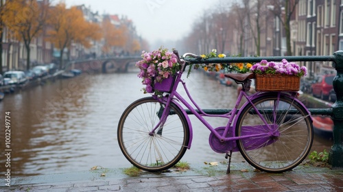 Purple bicycle adorned with flowers near a canal in Amsterdam during autumn