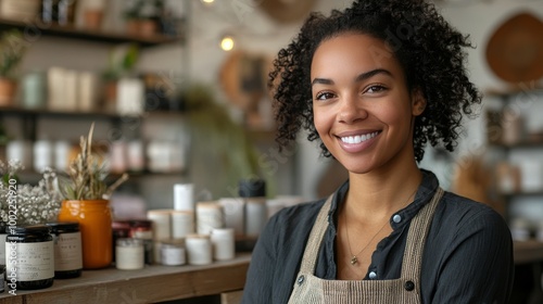 A smiling woman in a cozy shop displays handmade candles and natural products