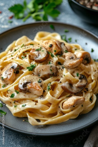 Creamy chicken fettuccine with mushrooms served on a rustic wooden table