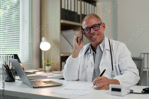 Male doctor, scientist, specialist working with laptop, making work calls, studying data, biological research at desk in office in hospital, clinic.