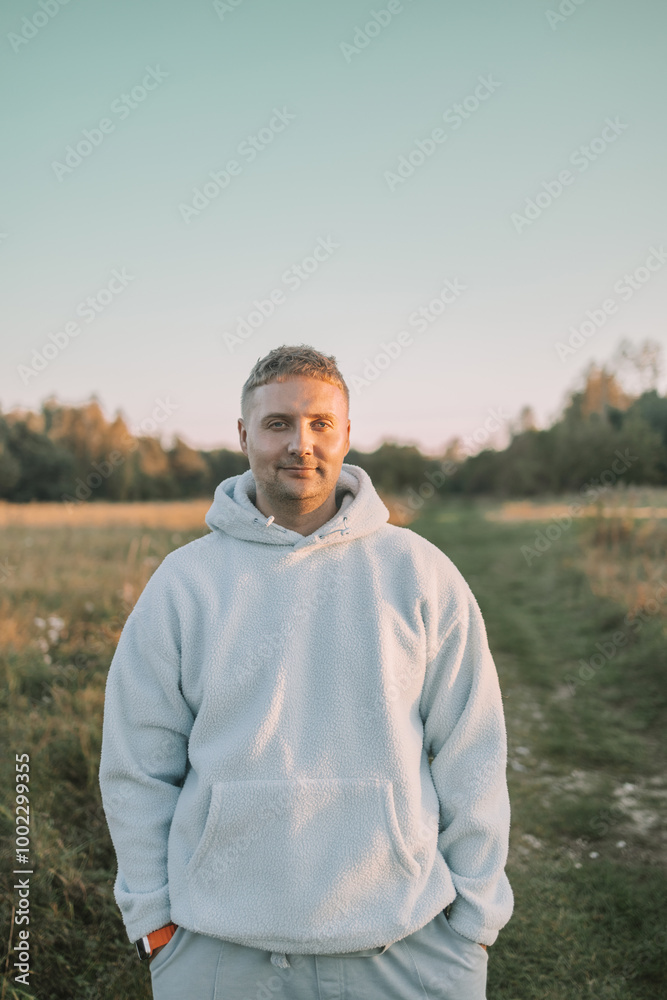 Portrait of happy Caucasian blonde man looking at camera outdoor, wearing blue cozy jacket walking rest relax in spring green city park go down alley sunshine lawn outdoors on nature. Urban lifestyle Portrait of happy Caucasian blonde man looking at camera outdoor, wearing blue cozy jacket walking rest relax in spring green city park go down alley sunshine lawn outdoors on nature. Urban lifestyle