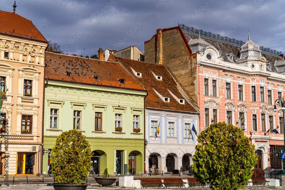 Brașov's autumn square charm. Colorful buildings line the square in Brașov, Romania, showcasing historical architecture against a cloudy autumn sky. Brașov's autumn square charm. Colorful buildings line the square in Brașov, Romania, showcasing historical architecture against a cloudy autumn sky.