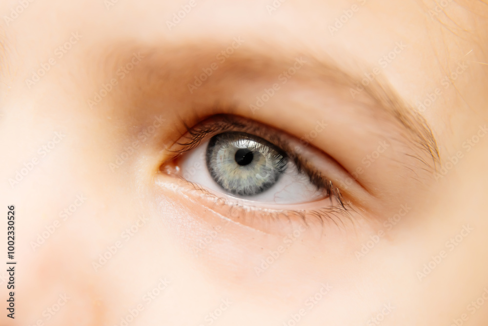Obraz premium Close-up of a girl's eyes, showcasing the beauty of her expressive gaze. This macro shot highlights the depth of her look, perfect for illustrating themes of beauty and childhood aesthetics.