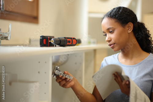 Photography Black woman checking instructions manual assembling furniture