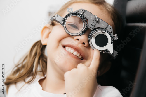 A little girl wearing glasses undergoes vision diagnostics in an ophthalmologist's office. An example of modern methods for diagnosing and treating children's vision. photo