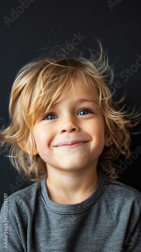 portrait of smiling blonde child on black background