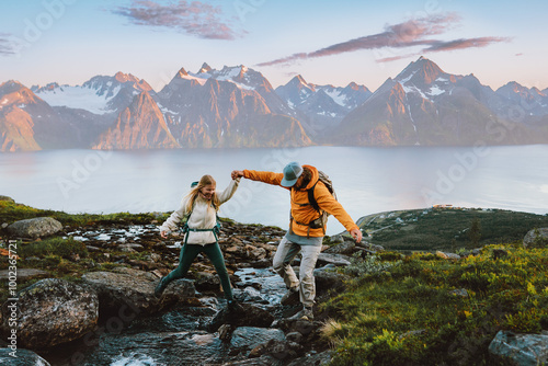 Couple hiking in Norway man helps woman cross river in mountains healthy lifestyle outdoor active family vacations adventure tour, friends exploring Lyngen Alps