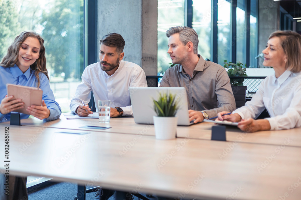 Happy four business people executive team working at laptop having discussion at office meeting showing financial project Happy four business people executive team working at laptop having discussion at office meeting showing financial project