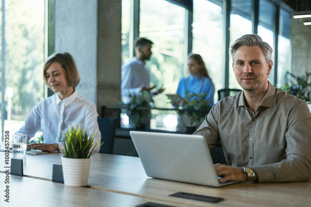 Businessman with colleagues in the background in office.