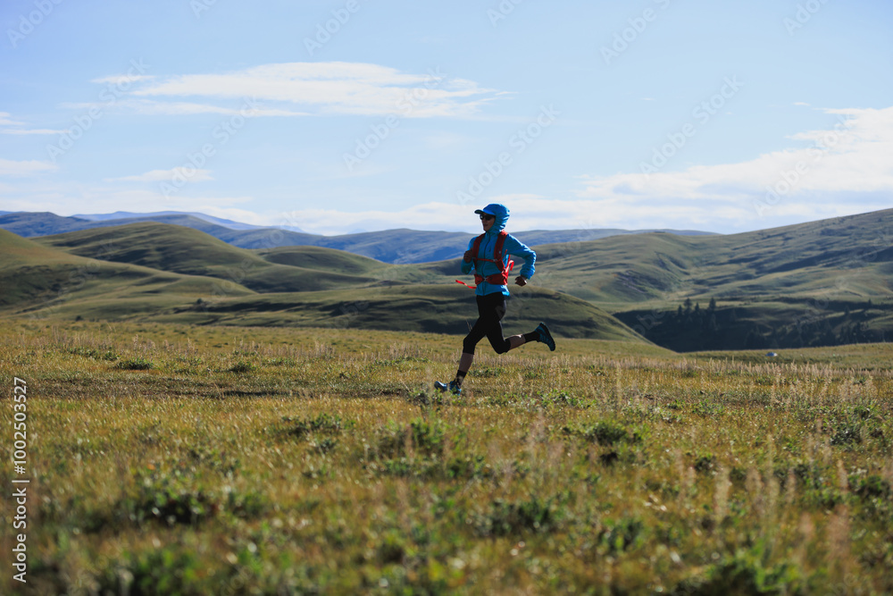 Fitness woman trail runner running in grassland Fitness woman trail runner running in grassland