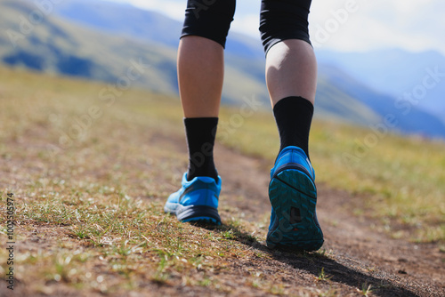 Fitness woman runner running at high altitude grassland mountain top road