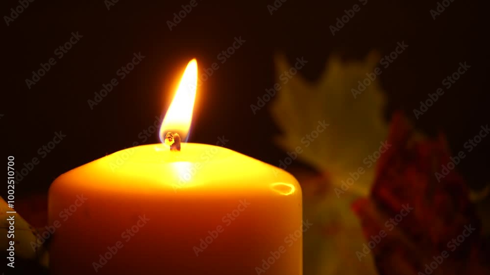 A cozy autumn scene featuring a flickering candle nestled among yellowed leaves in the evening. The warm glow creates an inviting and tranquil atmosphere, perfect for capturing the essence of fall A cozy autumn scene featuring a flickering candle nestled among yellowed leaves in the evening. The warm glow creates an inviting and tranquil atmosphere, perfect for capturing the essence of fall