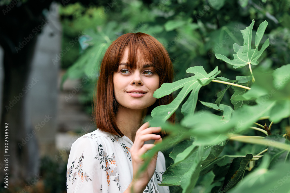 Vibrant woman with red hair surrounded by lush greenery in a garden setting Vibrant woman with red hair surrounded by lush greenery in a garden setting