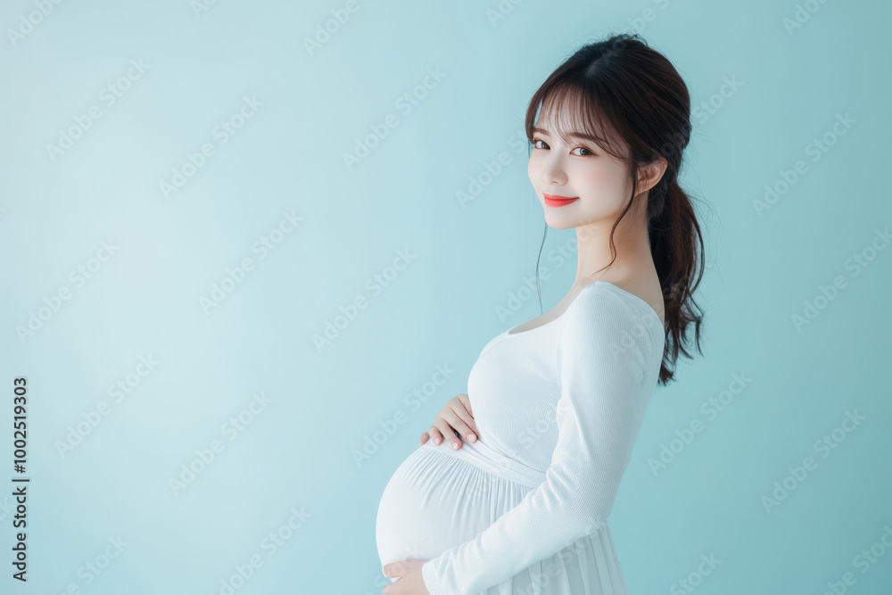 Pregnant japanese woman is posing sideways and holding her belly Pregnant japanese woman is posing sideways and holding her belly