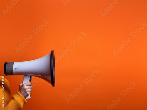 Obraz na płótnie A hand holding a white megaphone, emphasizing sales and discounts, set against a bold orange background to grab attention and create urgency. w salonie