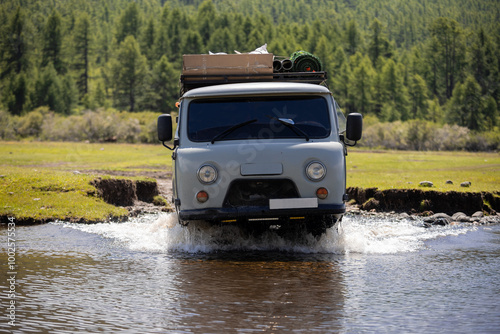 Russian off-road van with tourists crossing a river somewhere in Mongolia