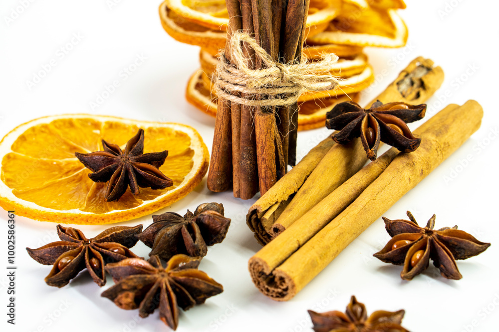 Cut orange and different spices on white background. Traditional festive winter beverage.Cinnamon, dried orange, anise and cloves Cut orange and different spices on white background. Traditional festive winter beverage.Cinnamon, dried orange, anise and cloves