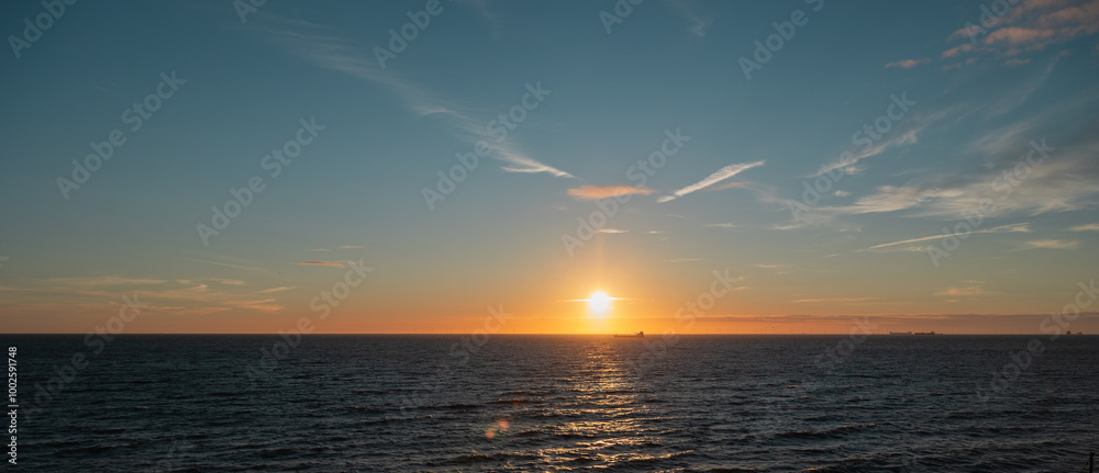 Wide panorama at sunset over the North Sea with ships on the horizon. Clear sky, landscape, Scheveningen, The Hague, Netherlands. Wide panorama at sunset over the North Sea with ships on the horizon. Clear sky, landscape, Scheveningen, The Hague, Netherlands.