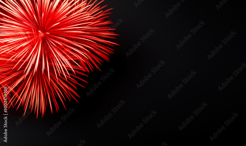 Brilliant red firework explosion against dark night sky. Vibrant pyrotechnic display with radial light trails. Festive celebration imagery with copy space for holiday or event themes.