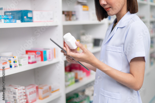 Fotografie Asian professional female pharmacist using tablet to check drug list Pharmacist